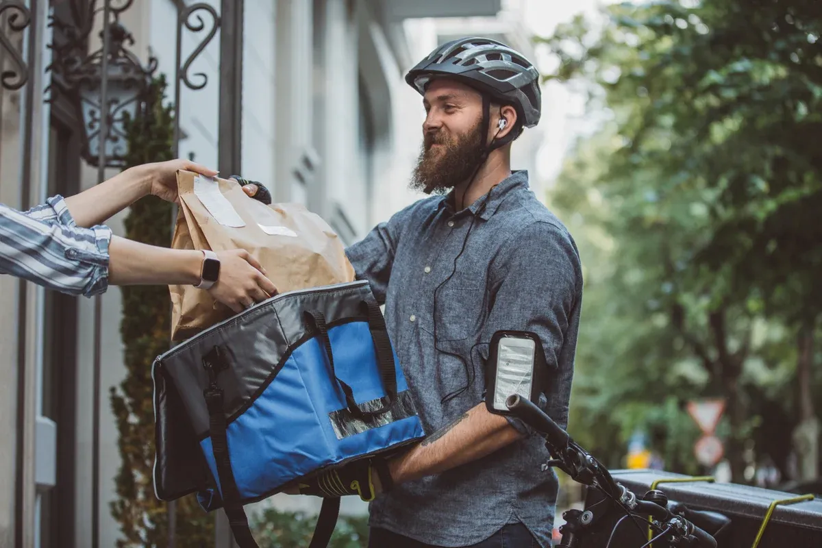Delivery rider handing a package to a customer